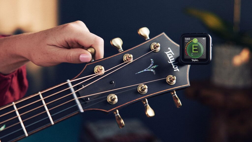 Image of a Taylor Beacon clip-on guitar tuner attached to a Taylor acoustic guitar headstock
