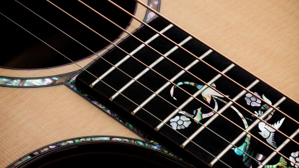Close-up of a Taylor Legacy 914ce acoustic-electric guitar showing detail of the abalone Cindy fretboard inlay and rosette