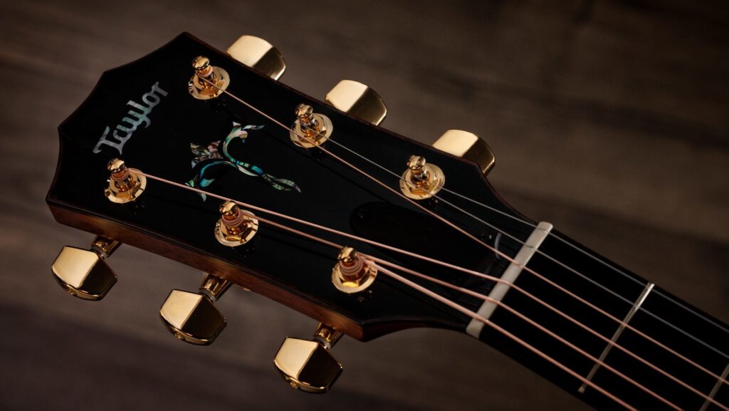 Gold tuning machines and abalone peghead inlays of a Taylor Legacy 914ce acoustic-electric guitar headstock